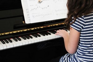 young piano student reading sheet music
